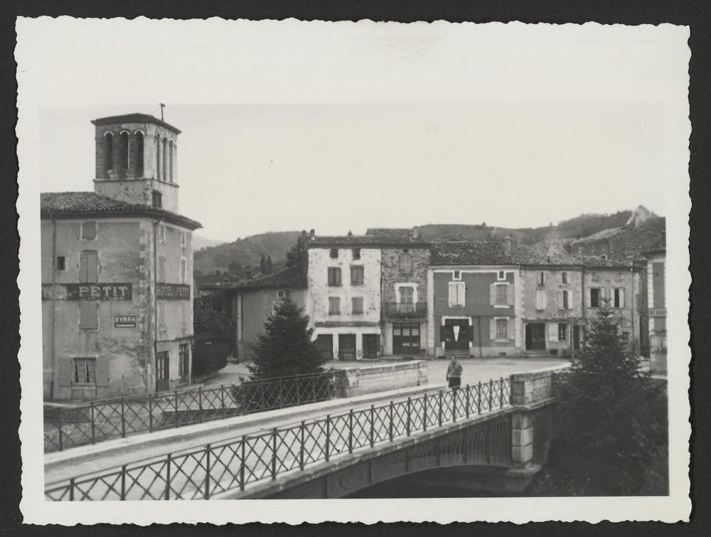 Pont donnant sur la place de l'église avec l'hôtel Petit à Bourdeaux